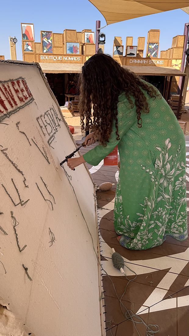 Artist hand-tufting the floor mural